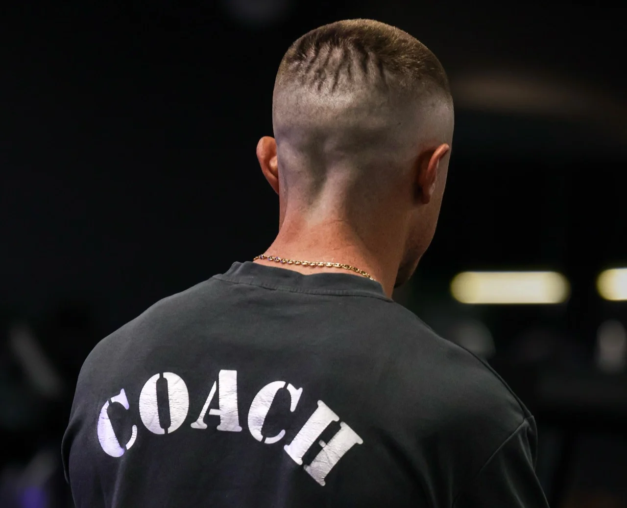 Coach sportif de dos dans une salle de fitness