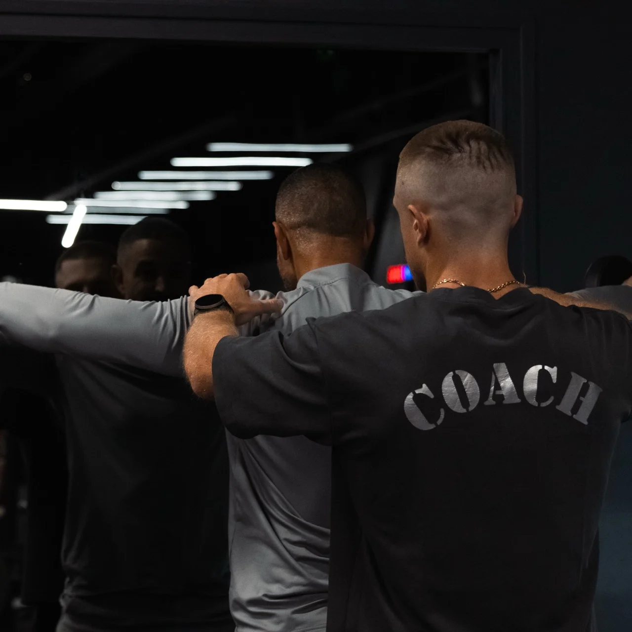 Coach accompagnant un exercice devant un miroir
